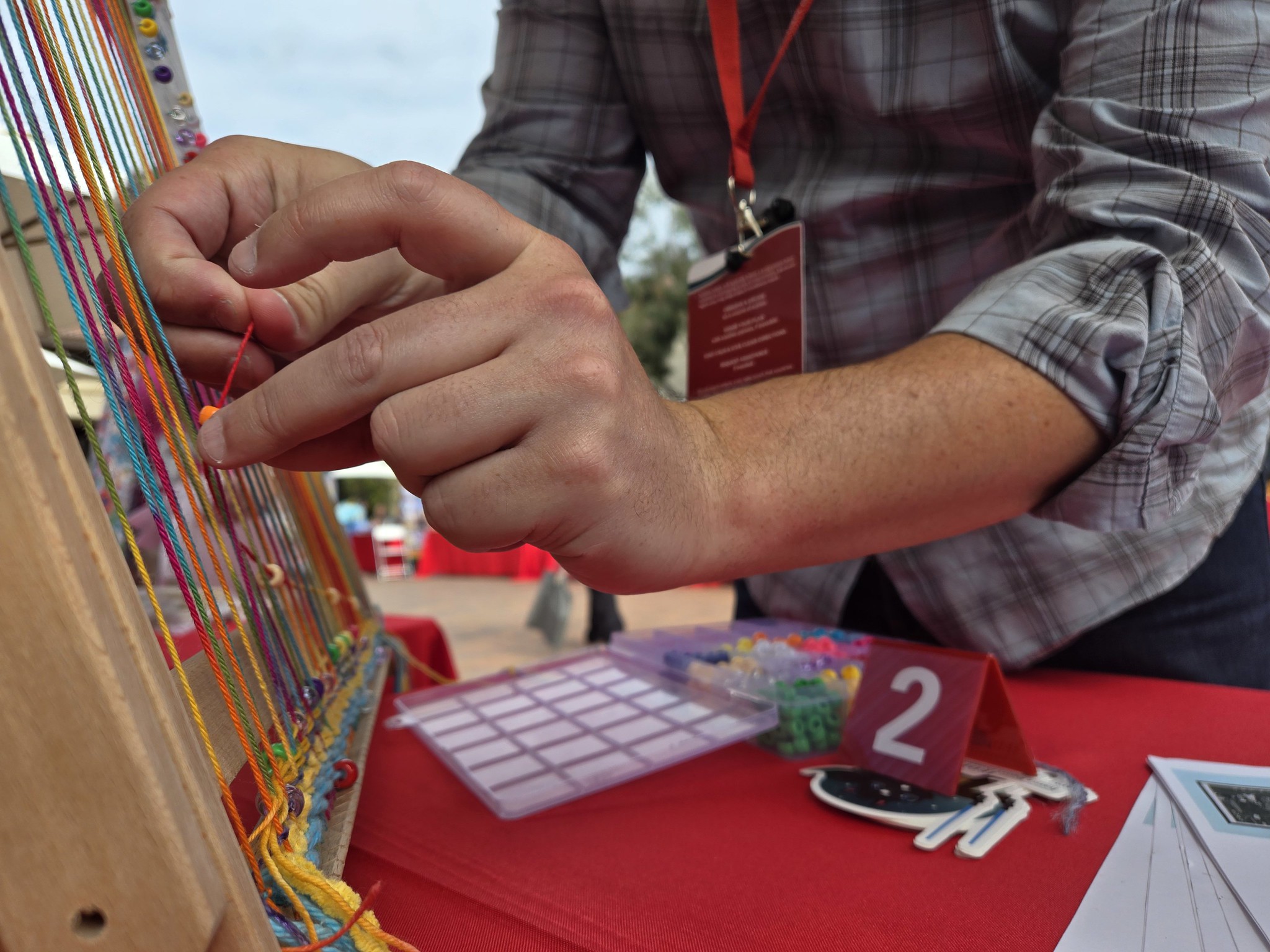 Hands weaving data onto the guestbook loom